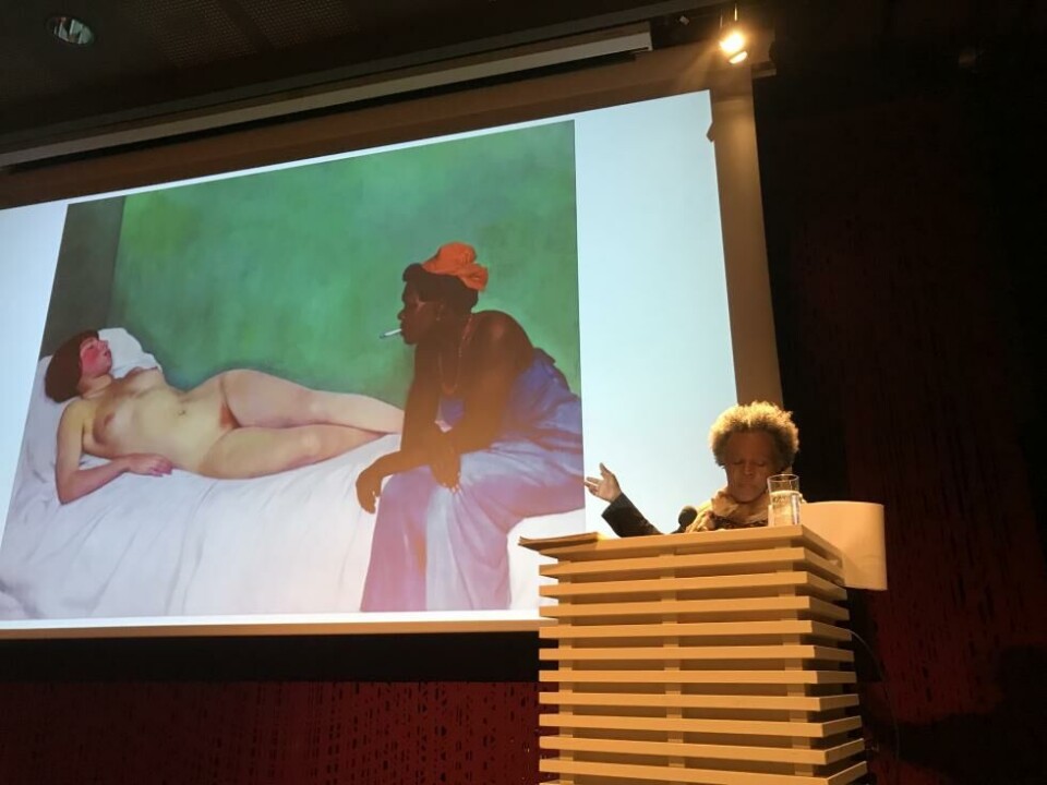 Claudia Rankine på Litteraturhuset, tirsdag 20. august. Bildet bak henspiller på Manets «Olympia», som var ett av utgangspunktene for forelesningen. Foto: Therese Bjørneboe