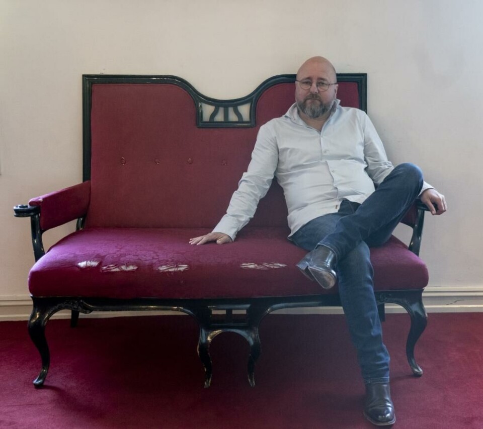 Teatersjef Kristian Sletun, sittende i en av de nedslitte sofaene i publikumsfoajeen, Amfiscenen. Foto: Leif Gabrielsen