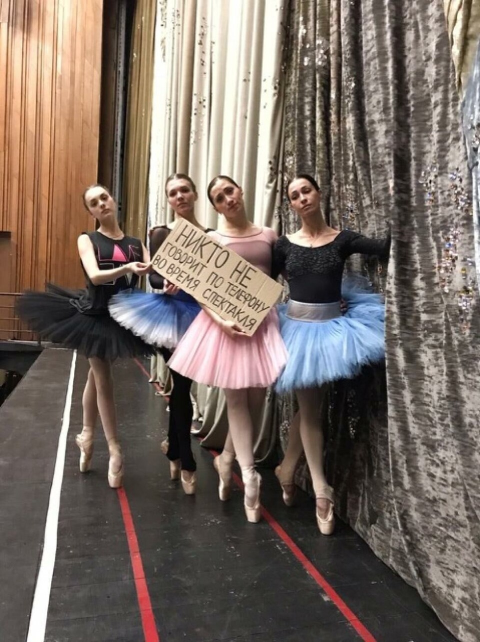 Ballettdansere i Krasnojarsk viser publikum at de er savnet. På plakaten står det: «Ingen som snakker i telefon under forestillingen».